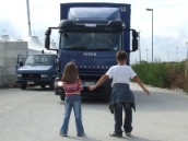 due bambini si oppongo al passaggio di un camion