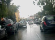 un'auto dei vigili che passa tra auto in doppia fila
