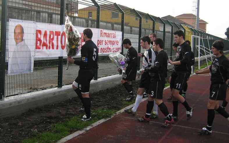 i giocatori portano fiori dinanzi alla foto del dirigente scomparso
