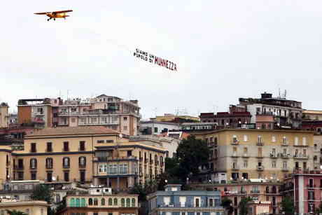 l'aeroplano sorvola Napoli con uno striscione che parla da sè